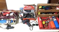 Overall view of soldering and welding supplies including Weller soldering kit, handheld soldering gun, and multiple gas canisters in a toolbox.
