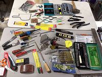 Overhead view of the tool assortment spread out on a table, showing the variety and condition of the hand tools including cases and loose items.