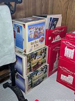 Six boxed model sets stacked, showing two boxes with detailed scenic imagery of village houses and a prominently displayed Great Halls of Fire box with fire trucks and Dalmatian firehouse logo.