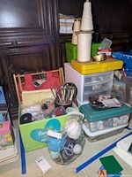 Overview of entire lot including yarn, knitting needles, storage boxes, and sewing tools.