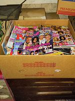Photo showing the top view inside the cardboard box filled with various teen and pop culture magazines, including People and Private Lives.