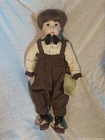 Full front view of the doll showing facial features, clothing details, and attached Franklin Heirloom tag.