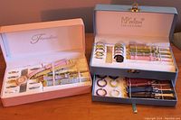 Full view of both interchangeable watch sets showing bands, bezels, and watch face in their boxes.