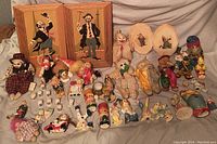 Overall assortment of clown collectibles on grey fabric.