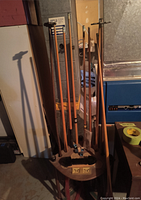 Photo showing the full wooden circular pool cue holder with six pool cues standing upright in slots.