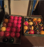 Open green box revealing mostly pink/red balls and some other solid colors in an organized arrangement