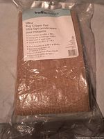 Photo of sealed package of new TrafficMaster Ultra rug gripper pad with product label showing sizing and care instructions.