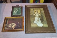 Three framed vintage glass wall art pieces laid out on a table showing size differences and frame details
