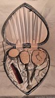 Heart-shaped vintage vanity set box opened showing silver hairbrush, comb, hand mirror, and vanity jar.