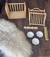 Photo showing all items laid out on the floor: natural curly sheepskin, two rattan storage pieces, a wavy wooden wall hook, three shell-shaped ceramic dishes, and a carved candle.