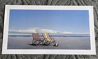 Full view of the signed art print "Side by Side" showing two striped deck chairs and a beach ball on a flat surface by ocean water, with blue sky and clouds.