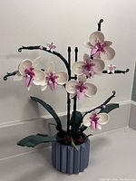 Full front view of the complete assembled LEGO orchid artificial plant set on a counter.