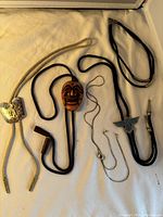Lot of four bolo ties displayed on a white surface, showing all ties and slides clearly.
