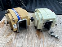 Two Powerwinch power boat electric winches side by side on wooden platform, one beige and one off-white housing, showing overall condition and appearance.