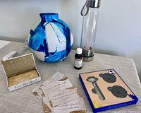 Full bundle showing the Saje AromaArt diffuser with blue and white pattern, Aveda oil blend bottle, glass water bottle with rose quartz, affirmation cards, and Sephora jade roller in packaging