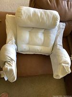 White deluxe bed lounger pillow on couch showing arms, backrest and removable bolster pillow placed separately.