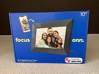 Photo of front of the sealed box showing the 10 inch Onn digital picture frame with Wi-Fi and Frameo app.