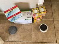 All items in the lot arranged on tiled floor, including lightbulb boxes and sliders.