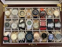 Top-down view of 24 watches in the open display case