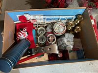 Photo of boxed Christmas decorations including candle holders, tins, tea light candles, and other small decor.