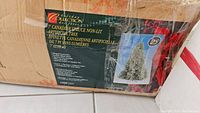 Photo of tree box showing branding, product details, and image of the artificial tree.