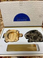 Packaging box showing two stone ashtrays and one onyx cigarette rest in molded foam insert, labeled Stato Marble Artist Sculpture.