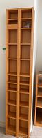 Two tall wooden shelving units side by side showing front view of shelving slots and adjustable features.