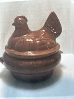 Front view of the brown glazed ceramic hen nest tureen showing detailed molded feathers and shape.