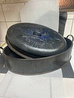 Wide view of vintage oval roaster and lid, showing overall rust and wear.