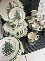 Stack of dinner and salad plates with Christmas tree design and green rim