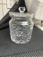 Front view of Waterford crystal biscuit jar with lid on top, showing detailed laurel leaf and diamond cut patterns in the crystal.
