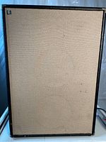 Front panel of the amplifier showing beige speaker grille with an 'E' logo at top left corner.