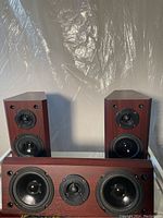 Pair of wood veneer rectangular bookshelf speakers showing front drivers with tweeters and mid-bass cones