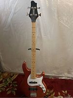 Full front view of red bass guitar showing body, neck and headstock