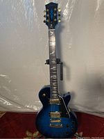 Full front view of Firefly Les Paul style electric guitar on stand
