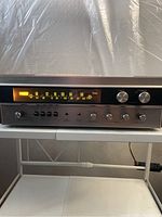 Front view of Sherwood S-7100 stereo receiver showing illuminated tuning frequency dial and control knobs.