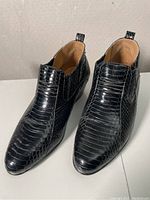 Pair of black snakeskin-textured shoes from Bruttini brand, showing side and top views, size 8.