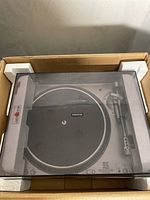 Turntable in original styrofoam packaging with clear dust cover inside shipping box