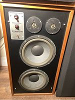 Frontal view of wooden Studiolab speaker cabinet showing two midrange drivers and one woofer.