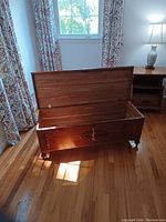 Photo showing an open cedar hope chest highlighting cedar interior and wooden exterior finish.