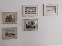 Five silver framed prints depicting historic Monmouth County buildings, arranged in two rows on a white wall