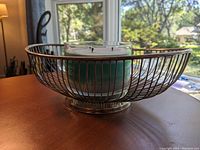 Side view of metal wire fruit bowl showing rounded rectangular shape and open wire design on table