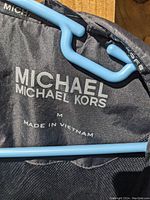 Close-up photo of the inner jacket lining label showing the brand MICHAEL MICHAEL KORS, size Medium, made in Vietnam.