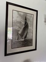 Framed black and white vintage America's Cup sailing print with intact glass showing a large sailboat on the water with dramatic clouds.