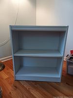 White bookshelf with two shelves, showing front view and overall structure.