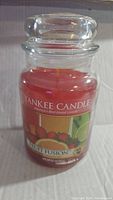 Full jar candle with lid, showing label and wax color