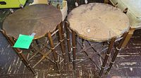 Pair of antique wooden side tables with removable tops shown side by side on wooden floor. Wear and surface scratches visible.