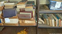 Books packed densely in cardboard boxes on metal shelves in a garage.