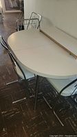 Oval table top and four chairs arranged around