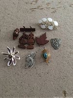 Top view of all eight vintage fashion jewelry pieces laid out on a flat surface.